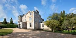 Exterior of Crossbasket Castle Hotel in Scotland with a clear blue sky.
