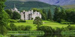 The grand castle of Inverlochy in Scotland surrounded by lush green landscapes with mountains in the background.