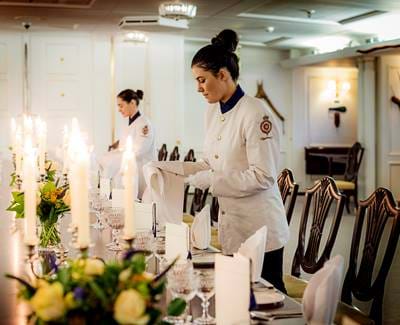 Tables being set for fine dining on the Royal Yacht Britannia