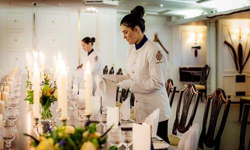 Tables being set for fine dining on the Royal Yacht Britannia