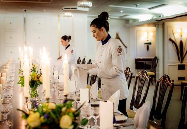 Tables being set for fine dining on the Royal Yacht Britannia