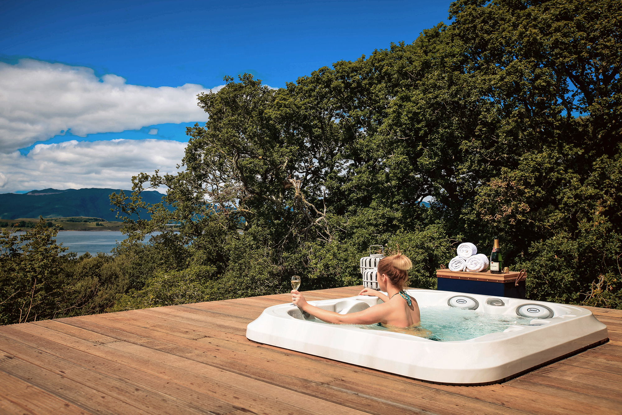 Woman drinking champagne in a jacuzzi with a view.