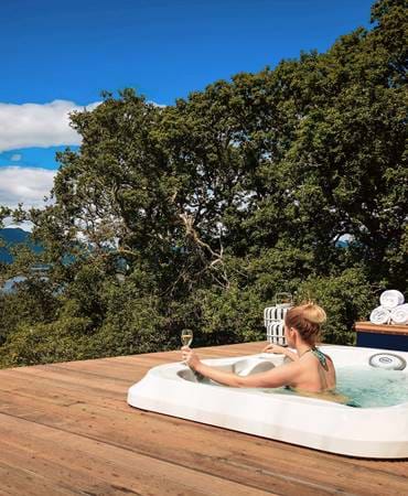 Woman drinking champagne in a jacuzzi with a view.