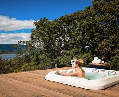 Woman drinking champagne in a jacuzzi with a view.