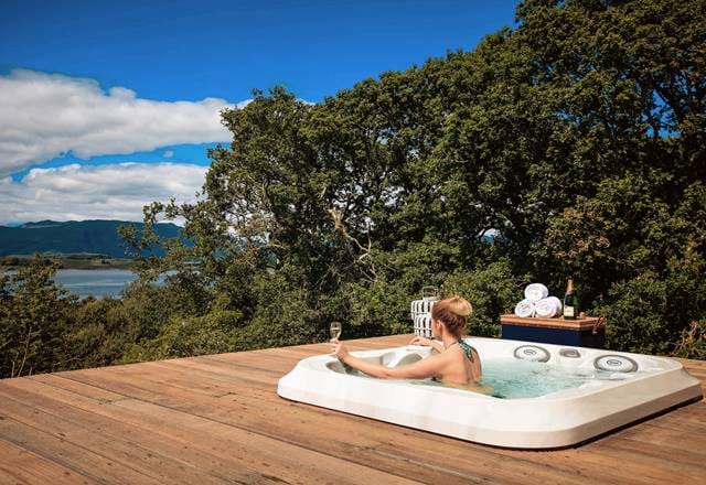 Woman drinking champagne in a jacuzzi with a view
